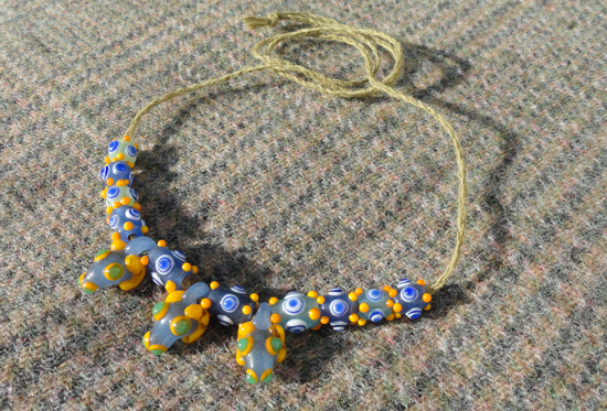 Kette mit 3 Widderköpfchen und winzigen Schichtaugenperlen mit Noppen, Slowenien/Vinica, 5.-4.Jh.v.Chr.